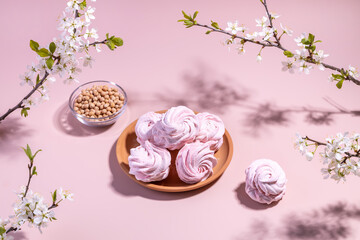 Vegan meringue, boiled chickpeas, aquafaba and plum blossom branches. The concept of vegan cuisine. A useful product. Selective focus.