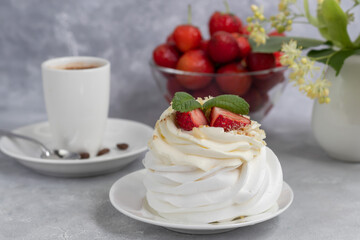 Pavlova meringue cakes with whipped cream and fresh strawberries, mint leaves. Selective focus.