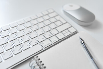 Office table desk. Workspace with sketchpad, keyboard, office supplies, pencil, on white table.