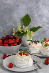 Pavlova meringue cakes with whipped cream and fresh strawberries, mint leaves. Selective focus.