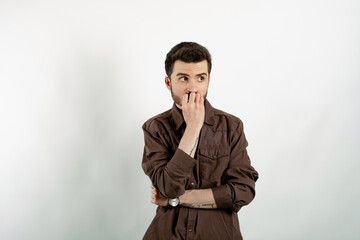 Handsome caucasian man wearing casual clothes posing isolated over white background touching chin and looking away. Search solution solve or make decision concept.