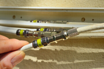 Anschluss der Koaxialkabel einer häuslichen TV-Anlage mit vier Endgeräten an den Quad-LNB einer Satelliten-Antenne © Hermann