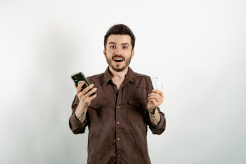 Caucasian man wearing brown shirt posing isolated over white background holding credit or debit...
