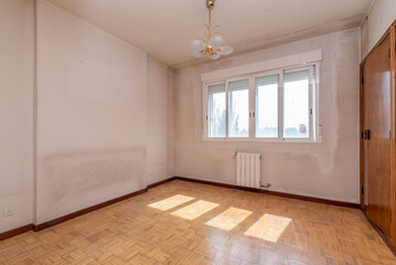 Fototapeta premium Empty room with fitted wardrobes on one side and double aluminum windows