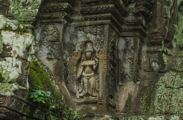 A sandstone carving of Nang Apsorn over the unrestored rock pile at Ta Prohm Temple, Angkor Wat, Cambodia.