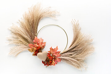 Dried floral wreath from dry pampas grass and Autumn leaves. Cardboard heart and Fall fecorations...