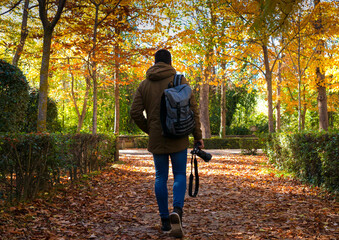Fototapeta premium Unrecognizable boy walking with camera in fall