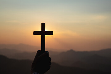 silhouette hand holding cross