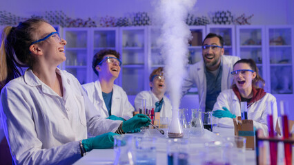 Excited science students with teacher doing chemical experiment in the laboratory at university.