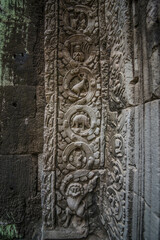 An ancient sandstone carving beside an arch that looks like a dinosaur at Ta Prohm Temple in Siem Reap Angkor Wat, Cambodia.