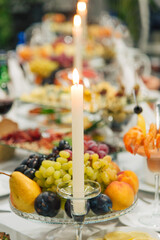 beautiful festive table setting with candles and fruits