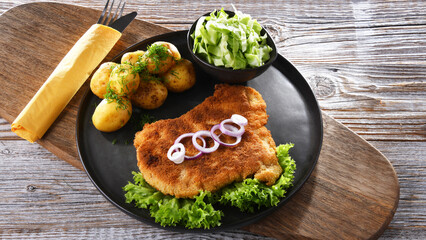 Pork cutlet coated with breadcrumbs with potatoes and cabbage
