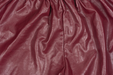 Texture of red leather material with folds. background for designers