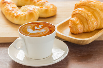 Cappuccino hot coffee latte art white cup and croissant 