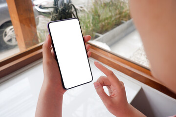 Mockup picture of business woman’s hands holding smart phone with white blank screen in modern...
