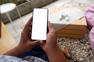 Mockup picture of business woman’s hands holding smart phone with white blank screen in modern place