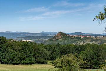 Gros plan sur le pic de Nonette au milieu de la plaine de la limagne avec ses nombreuses forets et en font la chaine de puys depuis le chemin de randonn&eacute;e de la croix d'Auzat dans le puy de d&ocirc;me