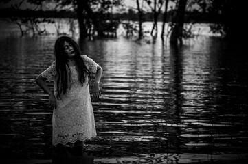 Naklejka premium Portrait of asian woman make up ghost face at the swamp,Horror in water scene,Scary at river,Halloween poster,Thailand people
