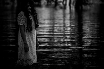Portrait of asian woman make up ghost face at the swamp,Horror in water scene,Scary at river,Halloween poster,Thailand people
