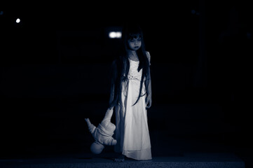 sad child ghost at night,Halloween  Festival concept,Friday 13th,Horror movie scene,A girl with doll