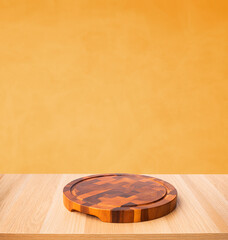 Chopping board on wood table with blur yellow background.