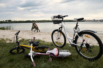 A cute family with a bicycles on a river band