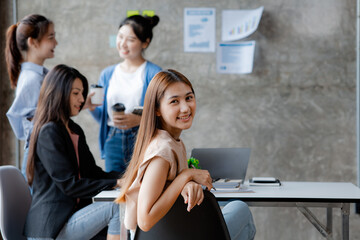 Asian teenage women sit in a startup company meeting room, young generation co-found and develop a plan to grow and differentiate a startup company. Startup company development by new generation.