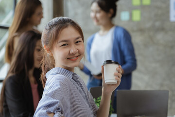 Asian teenage women sit in a startup company meeting room, young generation co-found and develop a plan to grow and differentiate a startup company. Startup company development by new generation.