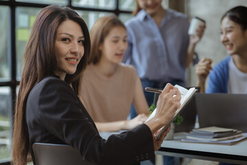 Asian teenage women sit in a startup company meeting room, young generation co-found and develop a plan to grow and differentiate a startup company. Startup company development by new generation.