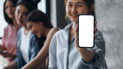 Asian woman holding white blank screen phone standing forward, smartphone blank screen for advertisement, smartphone application. Photo collage ideas for advertisements. copy space.