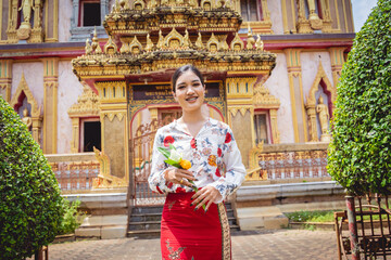 Beautiful Asian girl at big Buddhist temple dressed in traditional costume