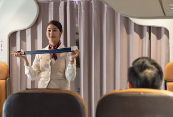Flight attendant safety demo fastening seat belt passenger airplane cabin