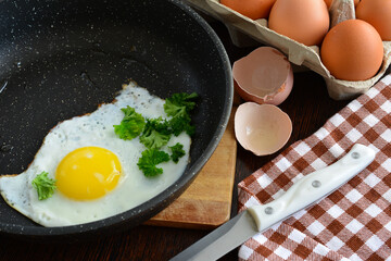 fried egg with yolk on frying pan on cutting board, close-up