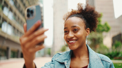 Closeup portret cute African girl with ponytail, wearing denim jacket makes stream, video call on...