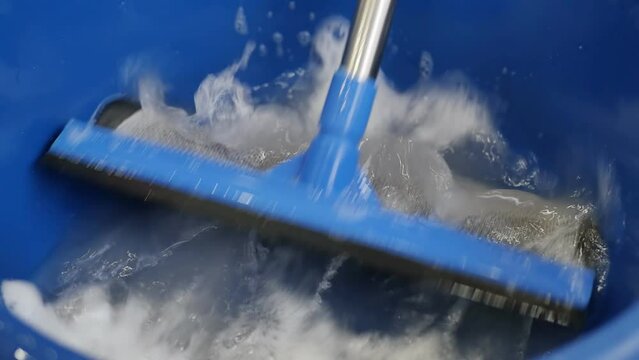 soak a combined double-sided mop made of foam and a rubber window cleaner in soapy water in a large bowl of soapy water and wash the window glass