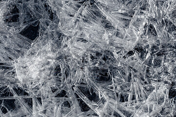 Natural background of ice crystals randomly covering a dark surface