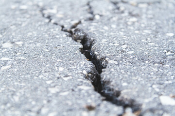 Stone wall with deep cracks. Break in the ground. Drought and consequences.