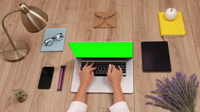 Workspace with laptop, girl's hands, notebook, flat lay, top view office table desk. Freelancer working place. Keyboard typing, office supplies, pencil. Ideas, notes plan writing concept, green screen