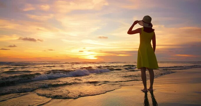 woman looks at sunset beach