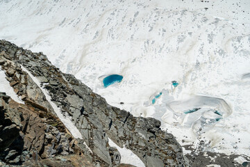A lake in winter where the ice is crystal clear blue. and covered with white snow.