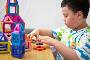 Obraz na płótnie Canvas boy building a toy house be creative