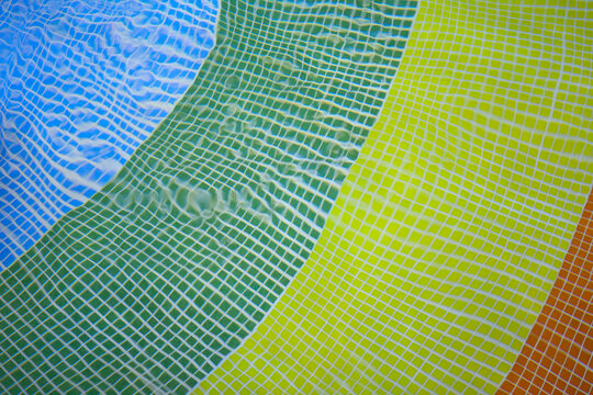 colofrul swimming pool floor bottom asymmetric due water movement. blue,yellow, green, glazed tiles
