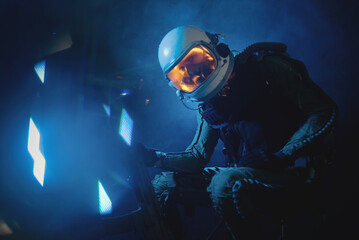 Obraz na płótnie Canvas Spaceman or star trooper in the helmet and with rifle in the blue smoke. Science fiction concept.