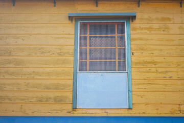 COLORIDA CASA AMARILLA CON PUERTA AZUL Y FACHADA DE MADERA