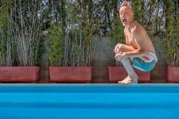 Middle aged white man diving into a swimming pool, cannonball style,with a funny expression