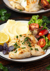Fried cod loin fillet with mashed potato and vegetable salad served with fresh lemon