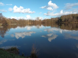 Wolken spiegeln sich im Noswendeler Stausee auf der Traumschleife Himmels Gääs Paad bei Noswendel im Landkreis Merzig-Wadern, Saarland. 