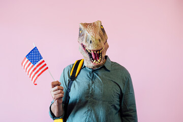 Man with lizard mask on pink background with colorful U.S.A. flag.