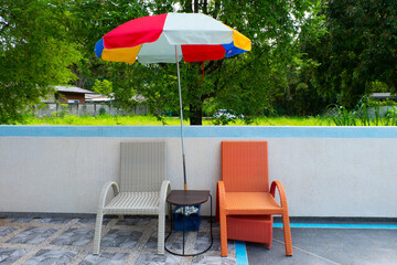 Empty Beach chairs with umbrella at Swimming pool.