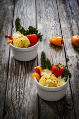 Roasted vegetables with mozzarella cheese on wooden table